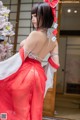 A woman in a red and white dress posing for a picture.