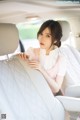 A woman sitting in the back seat of a car.