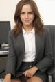 A woman in a business suit sitting in an office chair.