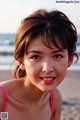 A young girl in a pink bikini on the beach.