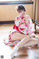 A woman in a kimono sitting on the floor.